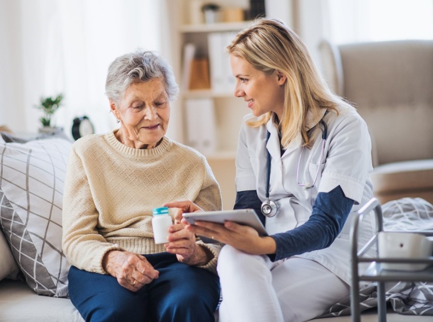 health-visitor-with-tablet-explaining-a-senior-woman-how-to-take-picture-id1125363243